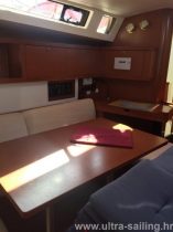 Tisch im Salon von Segelyacht Beneteau Oceanis 45 mit Navigationstisch im Hintergrund