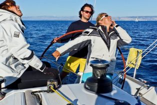 Teilnehmer der Ultra Segelschule im Cockpit von Segelboot Beneteau First 31.7