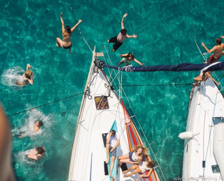 Gäste springen von Bug eines Segelbootes in einer Bucht in Kroatien